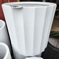 The GardenLite Grecian Cylinder White S 39x39cm planter stands upright with a price tag on its rim, displayed next to other similar-sized pots.