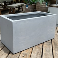 Rectangular concrete planter on a wooden deck.