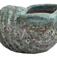 The GeoLite Lined Tall Cylinder Grey Wash S 33x44cm ceramic vessel has a textured, mottled finish in green and brown, reminiscent of a seashell.