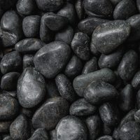 A close-up view of Pebbles Black 30-50mm from a 20kg bag, tightly packed together and highlighting their smooth, polished surfaces.