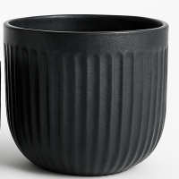 A matt black ceramic planter with vertical ridges, shown empty against a plain background.