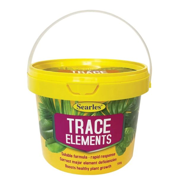 A yellow plastic tub labelled "Searles Trace Elements" with a white handle, used for correcting plant nutrient deficiencies and boosting growth.