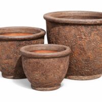 Three round, textured, brown ceramic plant pots of varying sizes are arranged side by side on a white background.