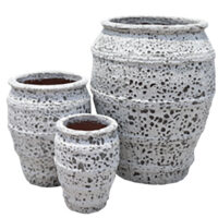 Three textured, white ceramic pots of varying sizes are grouped together against a plain background.